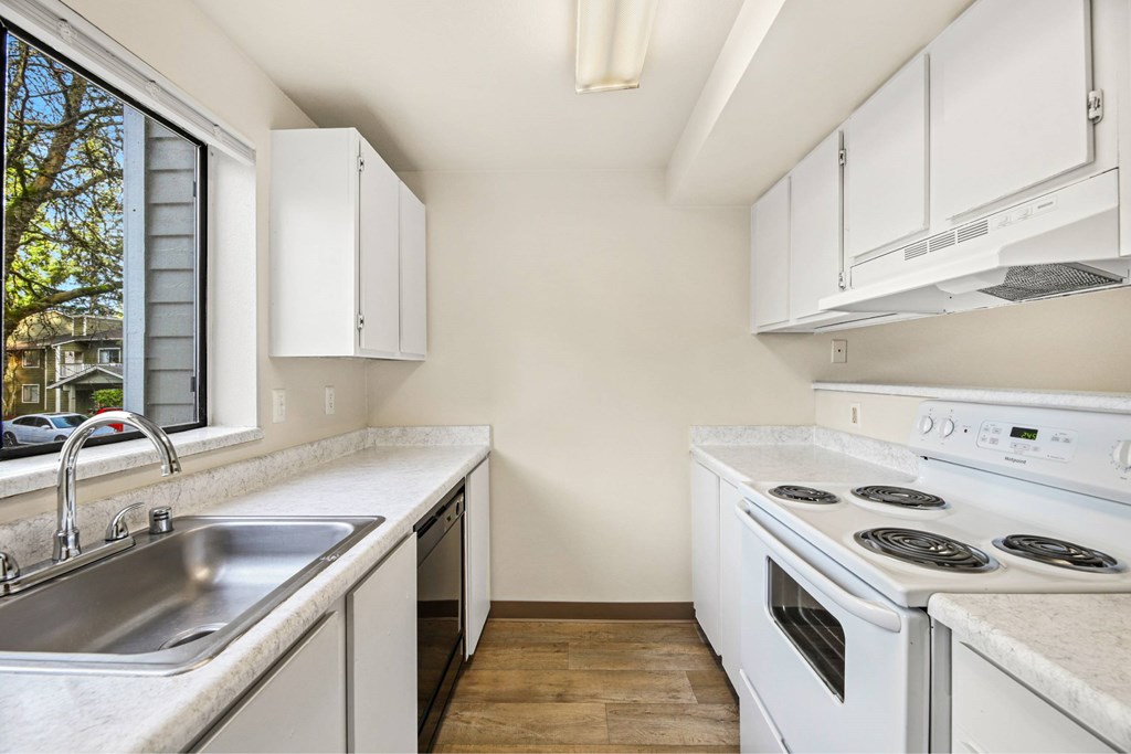 A kitchen with white cabinets and appliances.