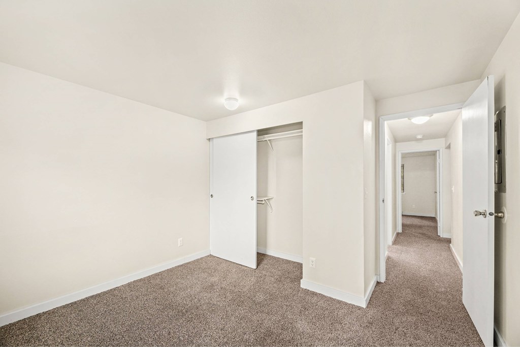 A long hallway with carpeted floors and white walls.