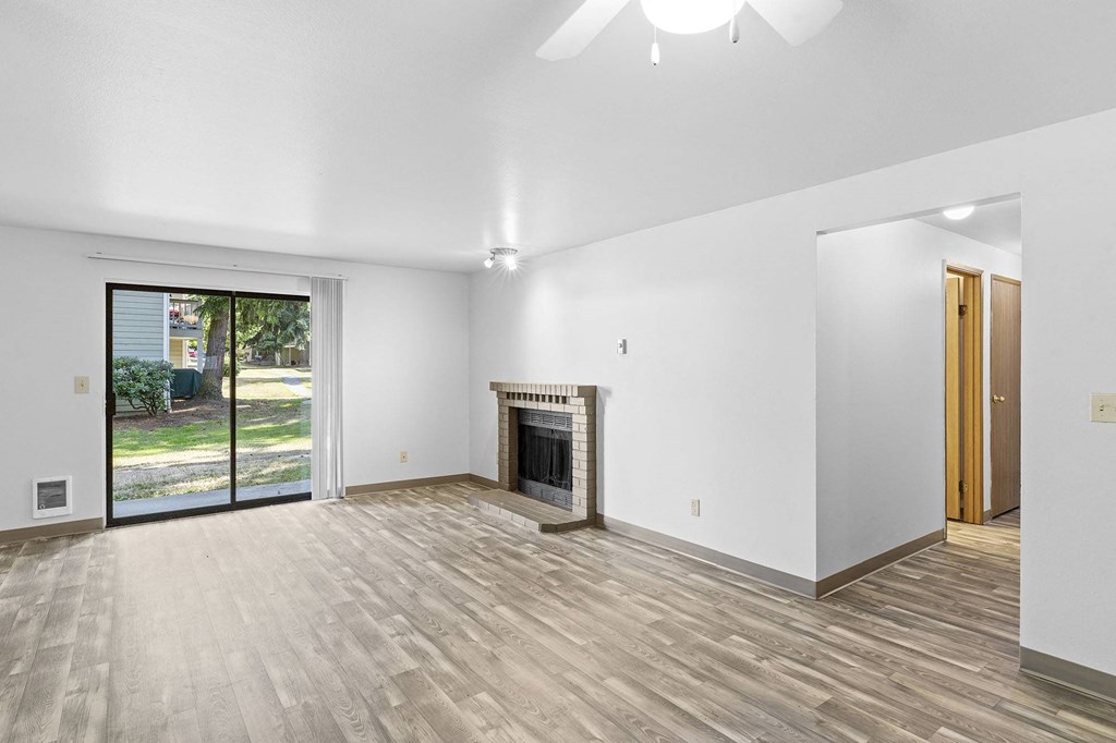 A room with a fireplace and sliding glass doors.