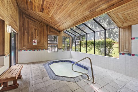 A wooden ceiling over a hot tub in a room.
