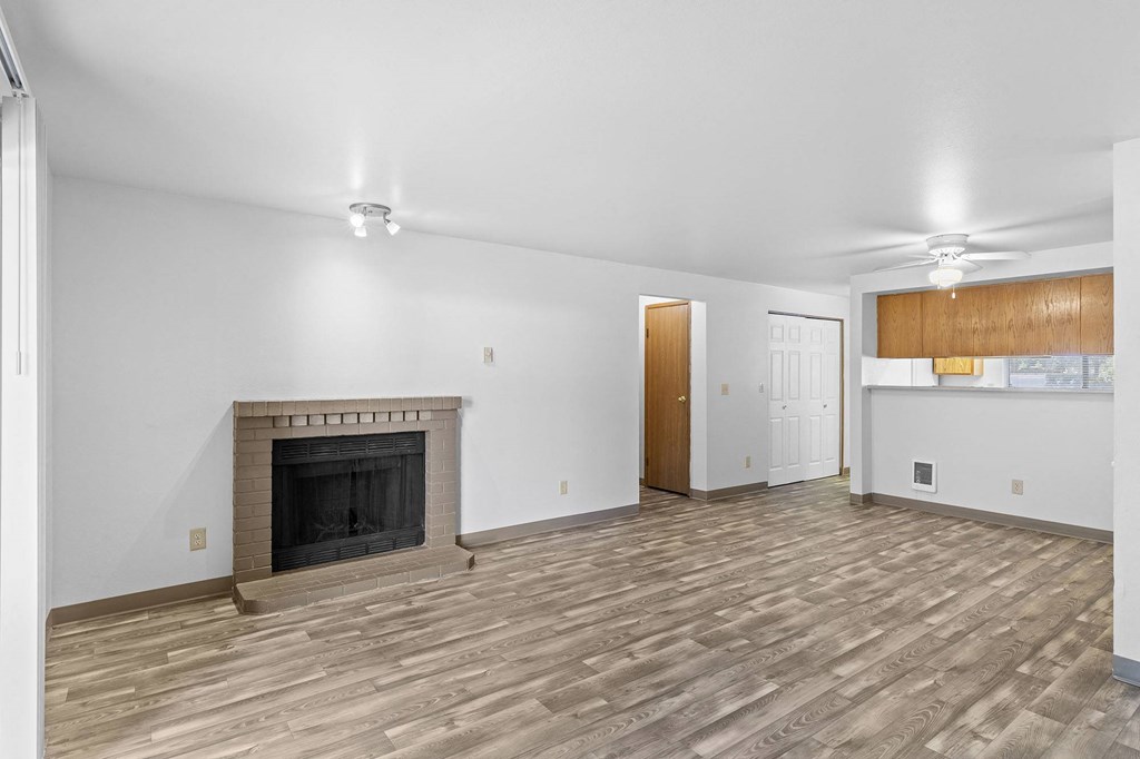 A room with a fireplace and wooden flooring.