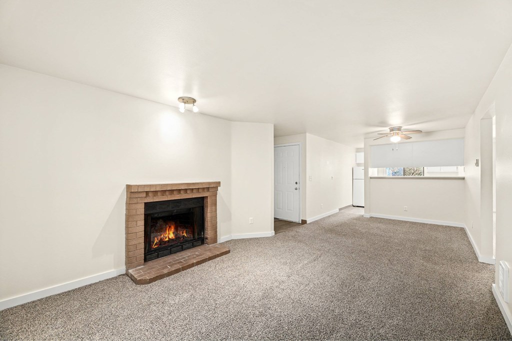 A room with a fireplace and carpeted floor.