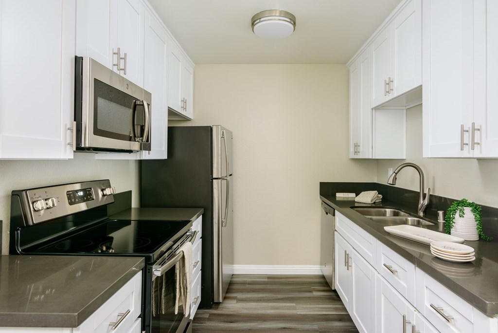 A kitchen with black countertops and white cabinets.
