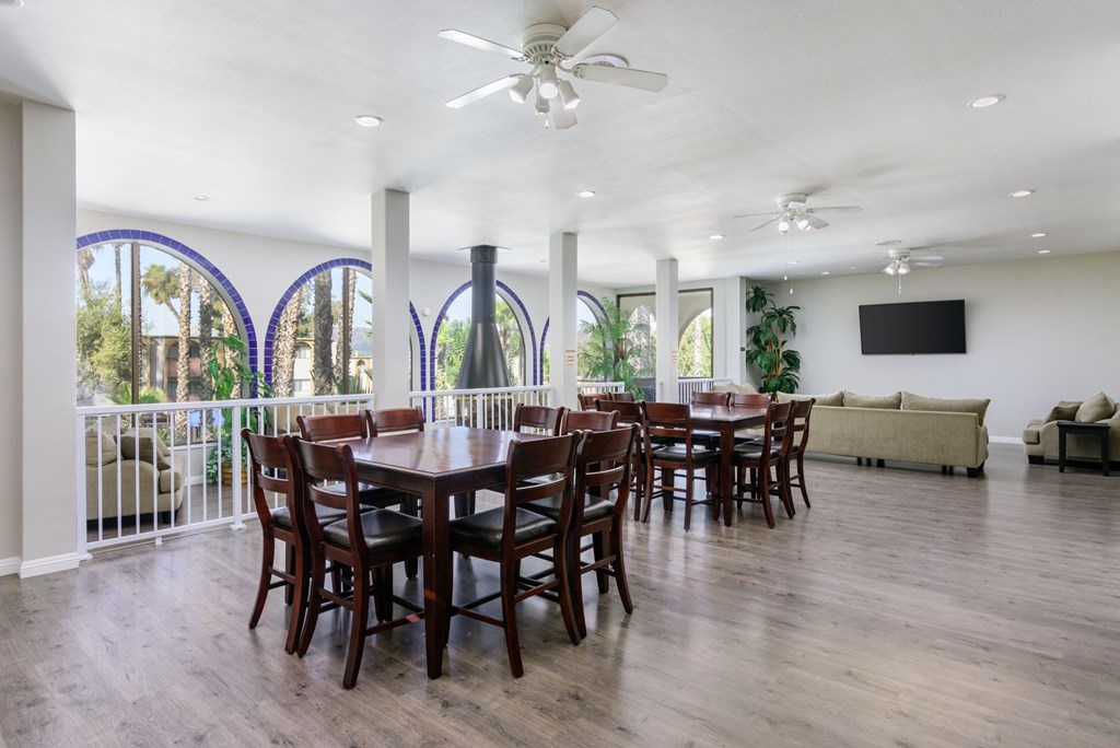 A dining room with a large table and chairs.