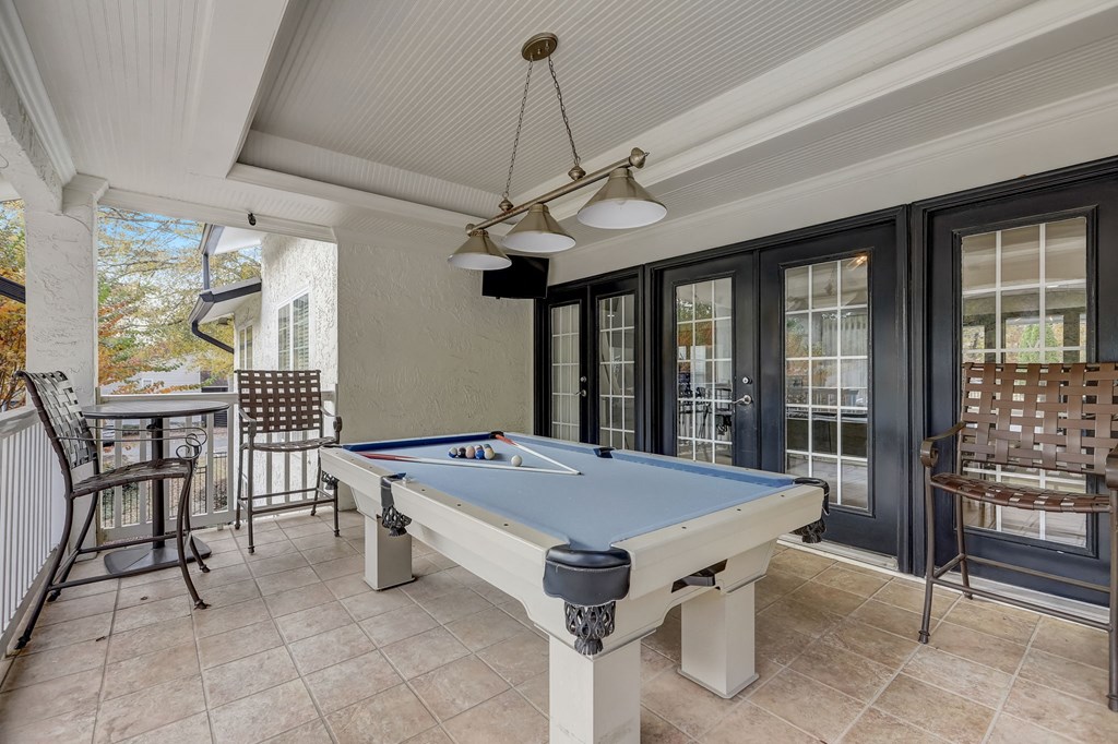 a pool table in the porch of a house with a patio