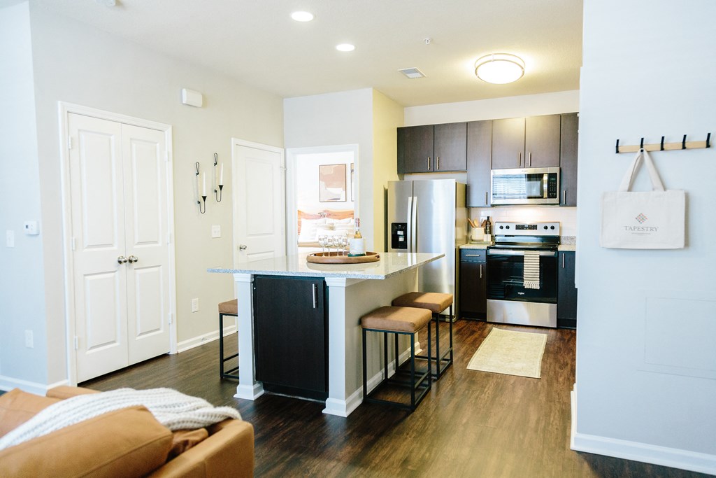 a kitchen and living room with an island and a refrigerator