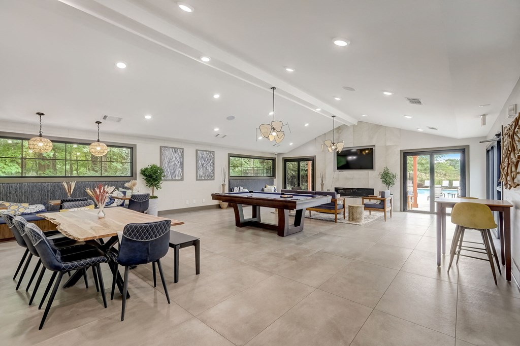 the entertaining room has a large table with chairs and a tv