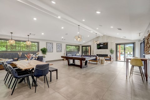 the entertaining room has a large table with chairs and a tv