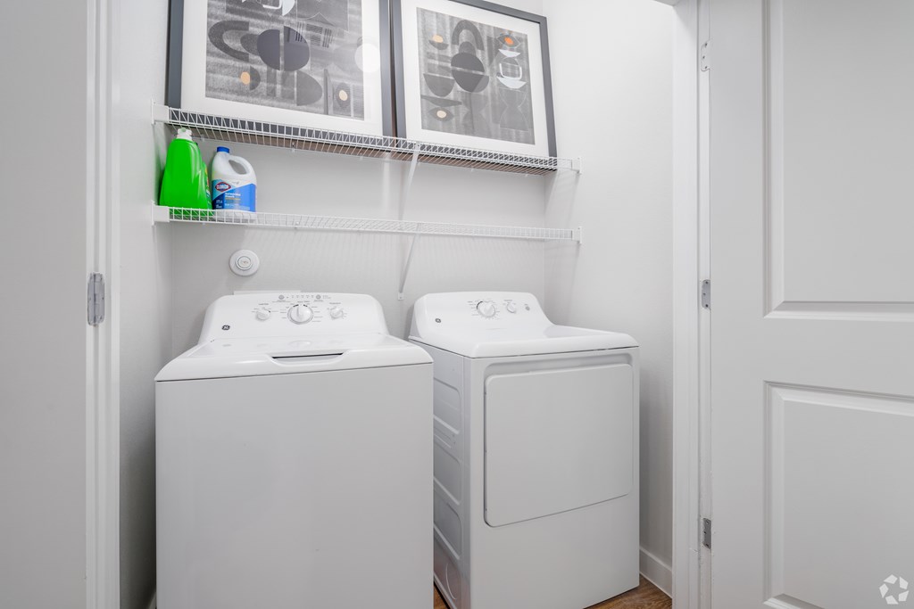 Two white front loading washing machines in a laundry room.
