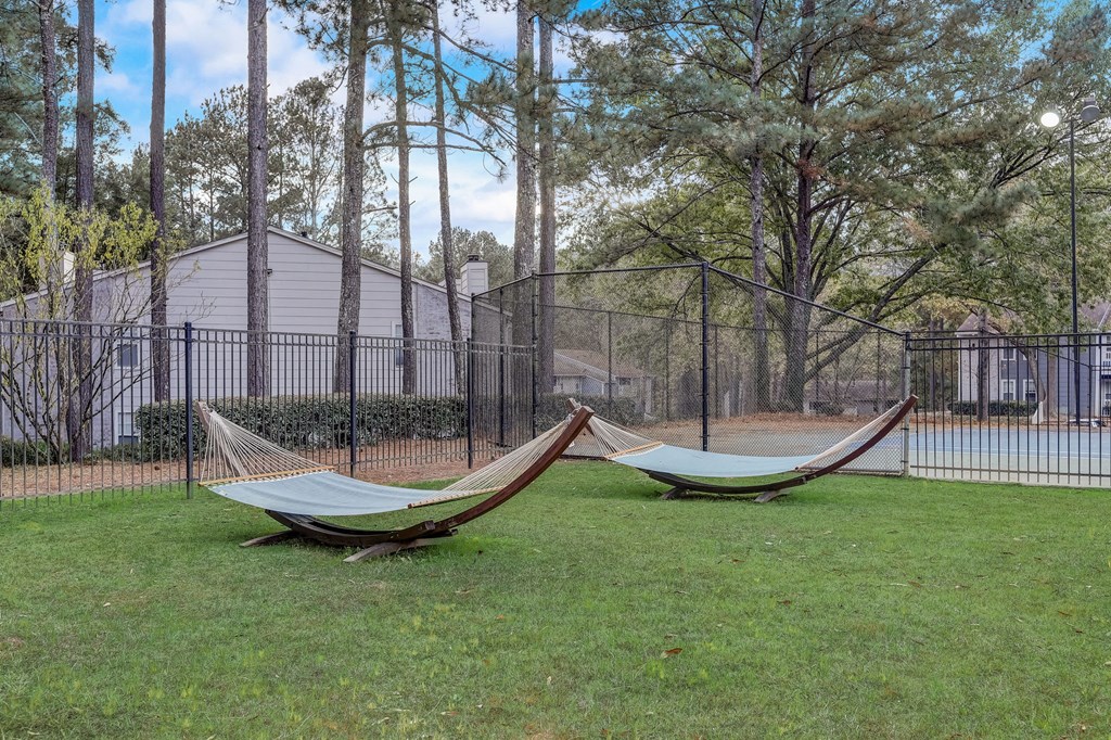 two hammocks in the grass in front of a fence at Veridian at Sandy Springs