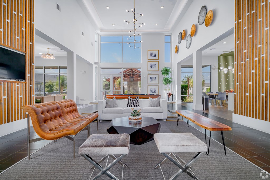 A modern living room with a brown leather sofa and a grey rug.