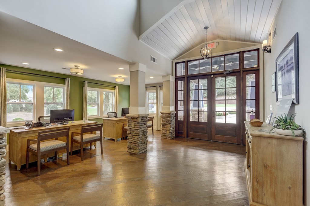 the home has a large office with a wood floor and glass doors
