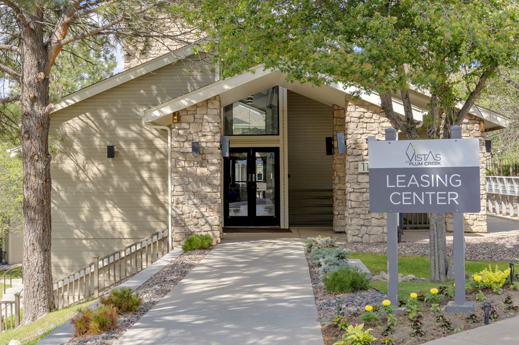 A building with a sign that says "Leasing Center" in front of it.