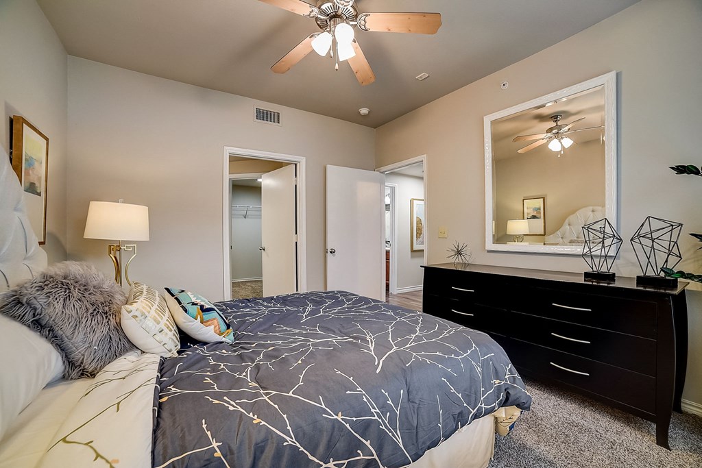 a bedroom with a large bed and a large mirror