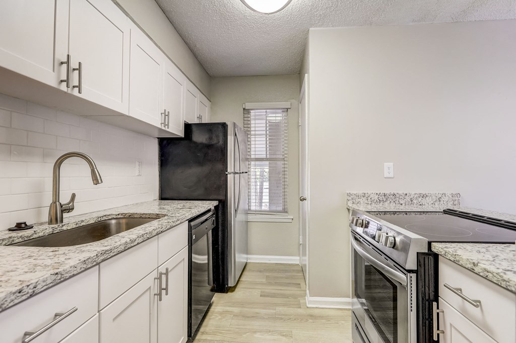 a renovated kitchen with white cabinets and a sink and a stove at Veridian