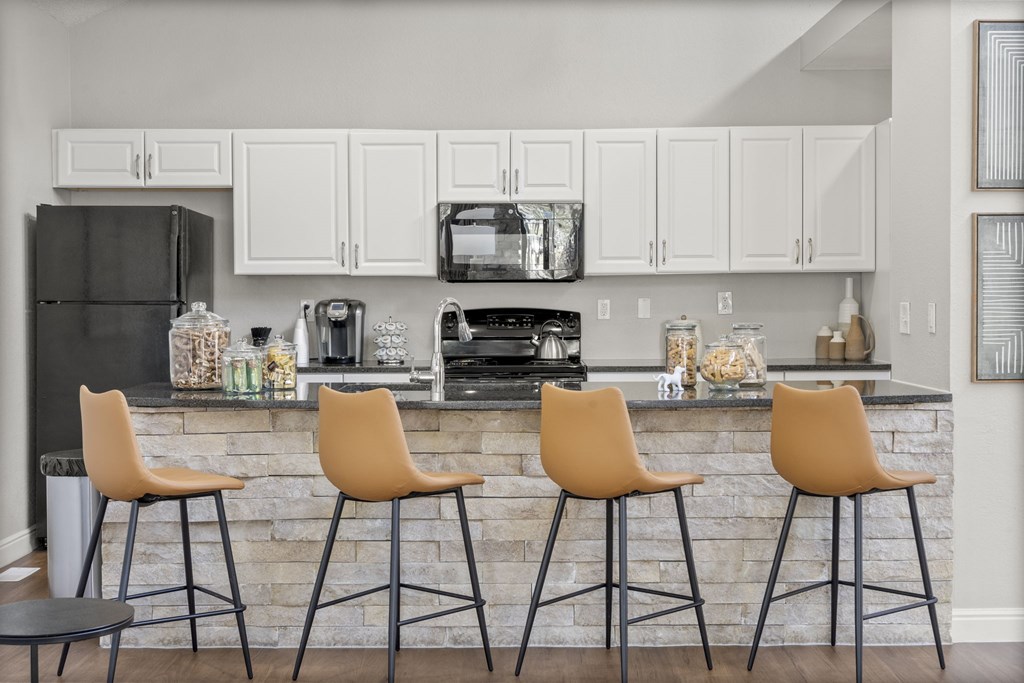 Two tan barstools sit in front of a stone bar.