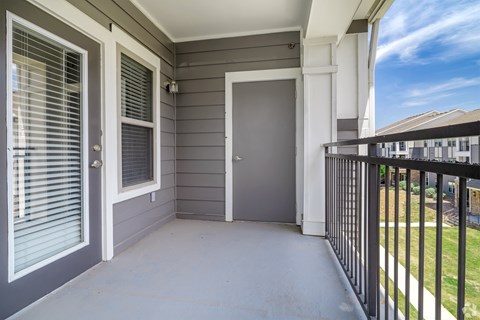 A grey door is on the left and a black railing is on the right.