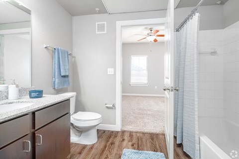 A bathroom with a toilet, sink, and a fan.