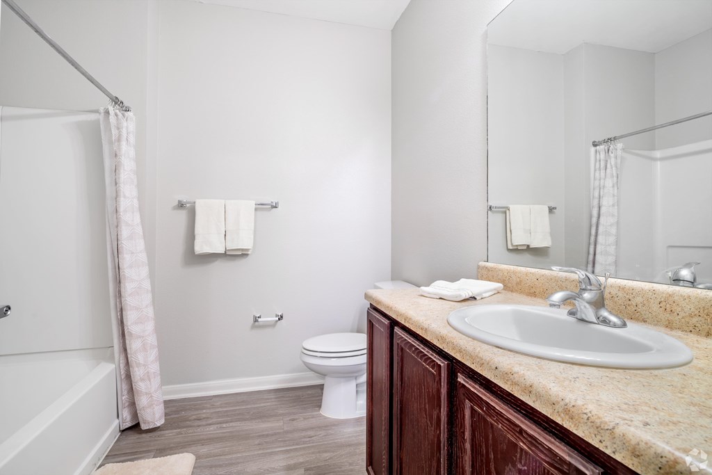 A bathroom with a toilet, sink, and bathtub.
