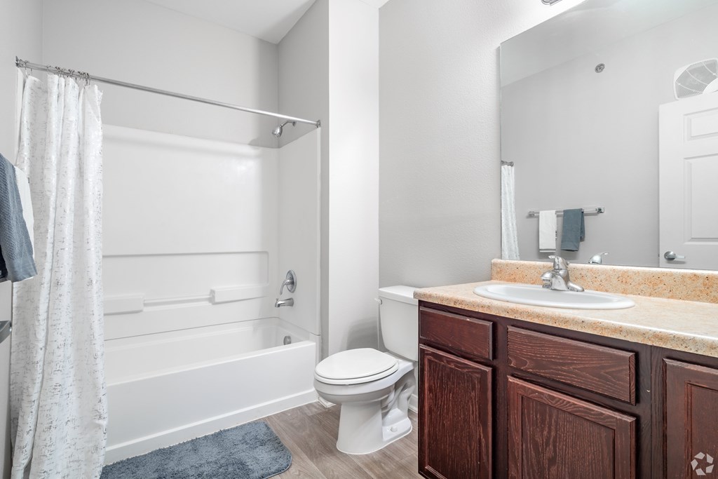 A white bathroom with a toilet, sink, and bathtub.