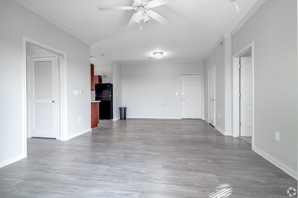A spacious room with a ceiling fan and a wooden floor.