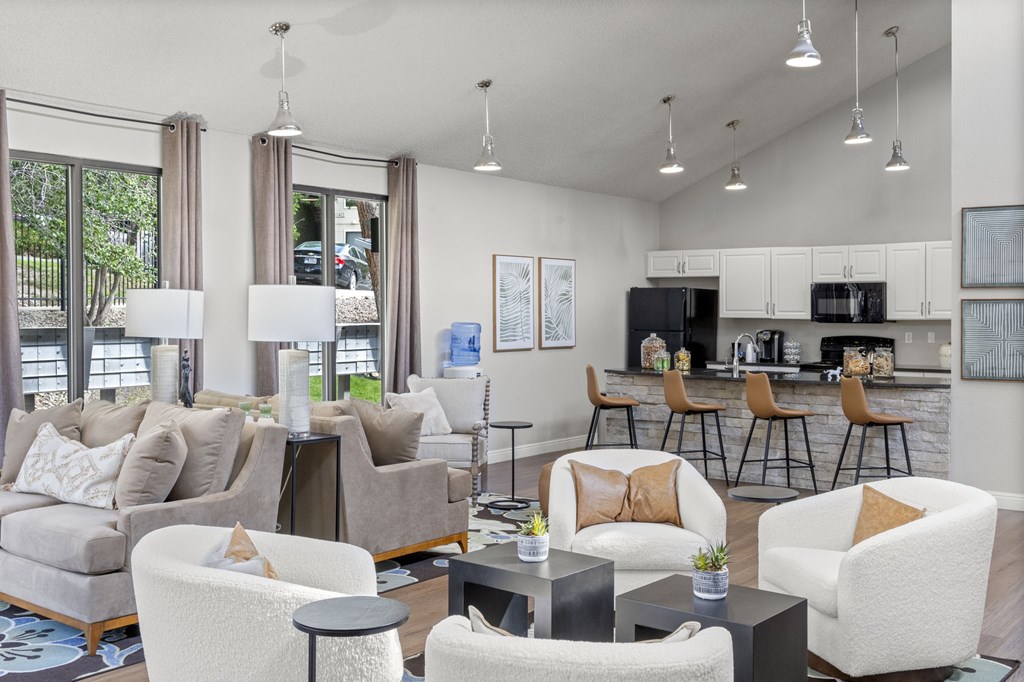 A modern living room with a kitchen in the background.