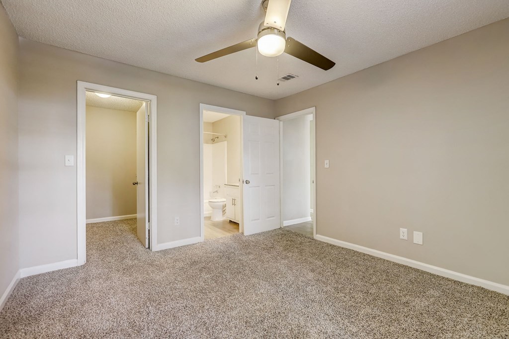 a living room with a ceiling fan and a door to a bathroom at Veridian at Sandy Springs