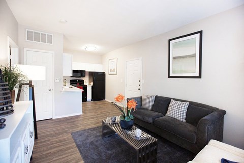 A living room with a black couch and a coffee table.