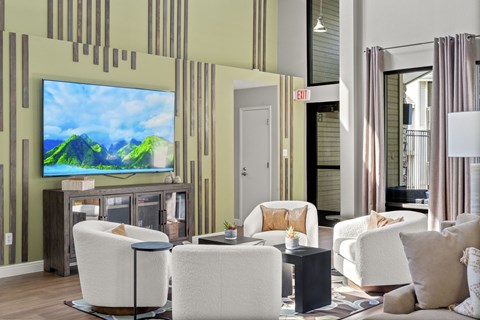 A living room with a large television and comfortable seating.