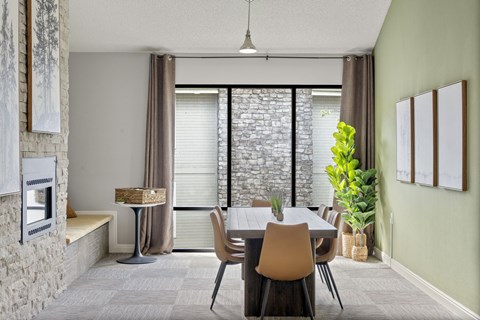 A dining room with a table and chairs.