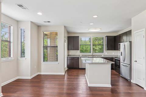 A kitchen with a white island and stainless steel appliances.