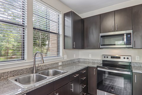 A kitchen with a stainless steel oven and microwave.