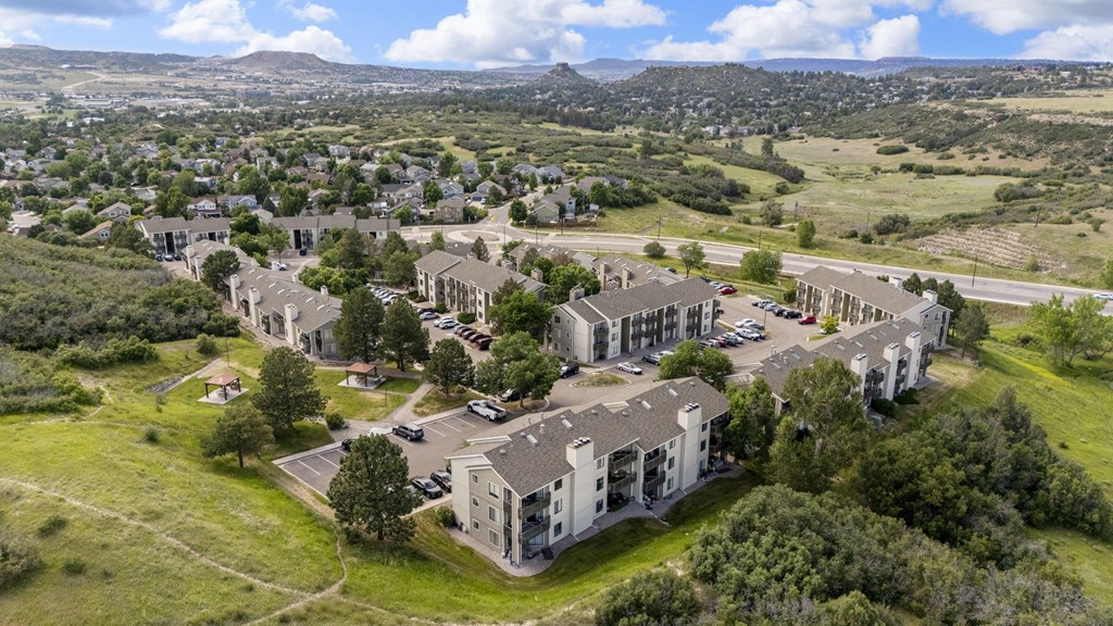 A large building complex with a parking lot in front of it.