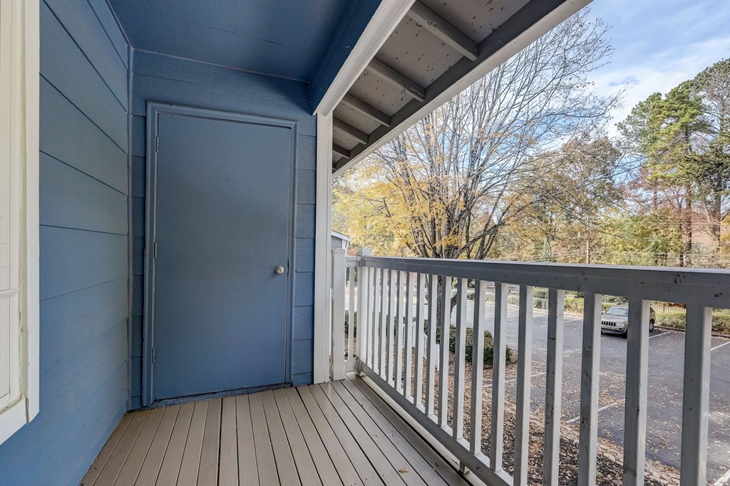 the view from the deck of a blue house with a blue door and a balcony