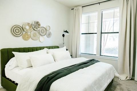 a bedroom with a large white bed with white sheets and pillows
