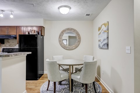 A kitchen with a table and chairs.