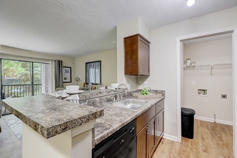A kitchen with a marble countertop and black appliances.