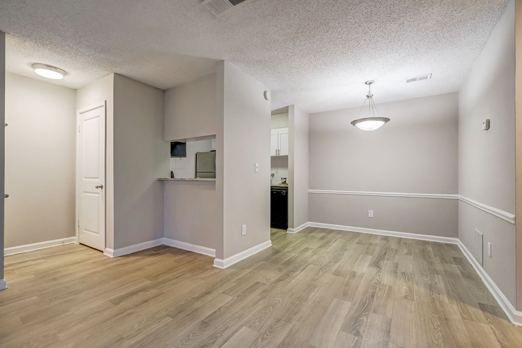 an open concept dining and living room with wood flooring and a kitchen at Veridian at Sandy Springs GA