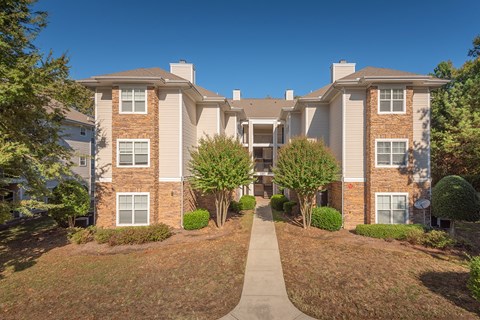 A residential building with a pathway leading to the entrance.