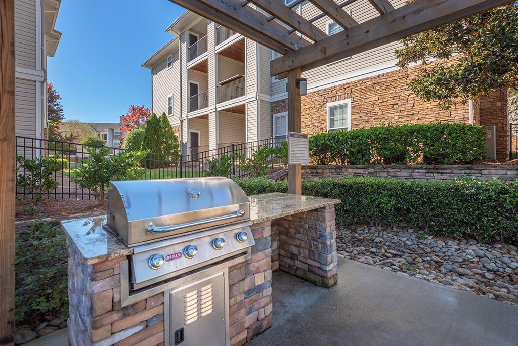 a barbecue grill on a brick wall in front of an apartment building