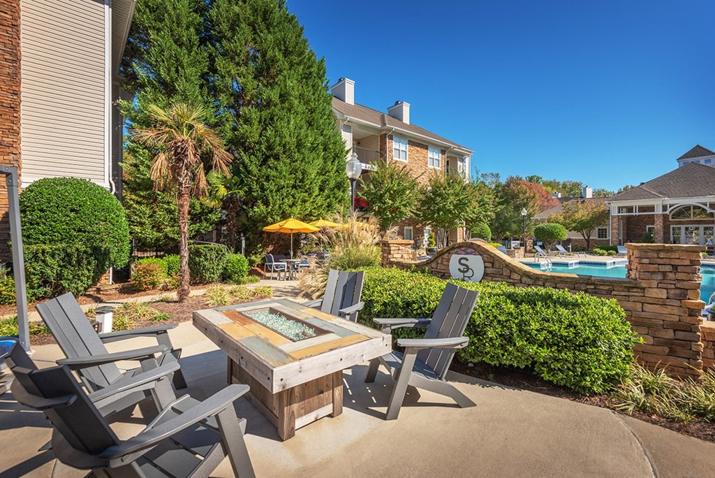 a patio with a table and chairs near a swimming pool