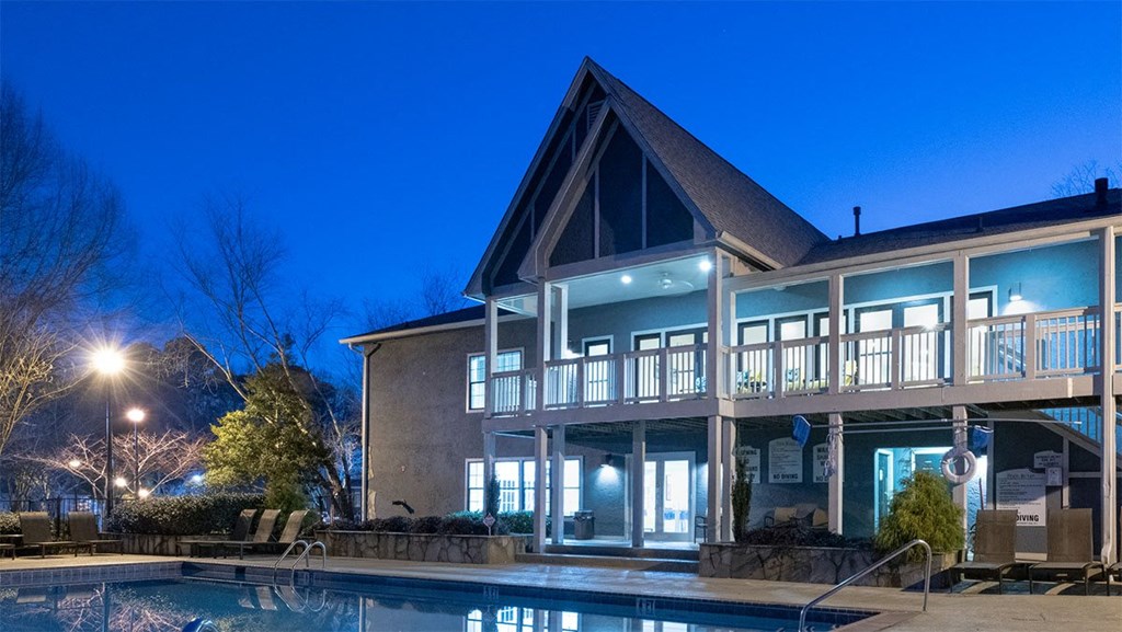 “Night view of pool deck and lounge chairs at Amberlake Village