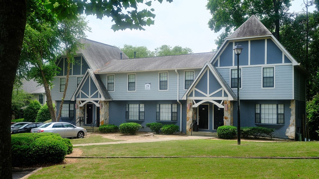a blue building at Amberlake Village apartments with a car parked in front of it