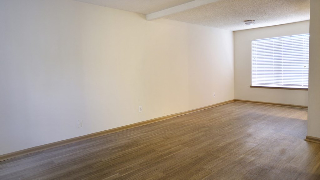 a bedroom with hardwood floors and a large window