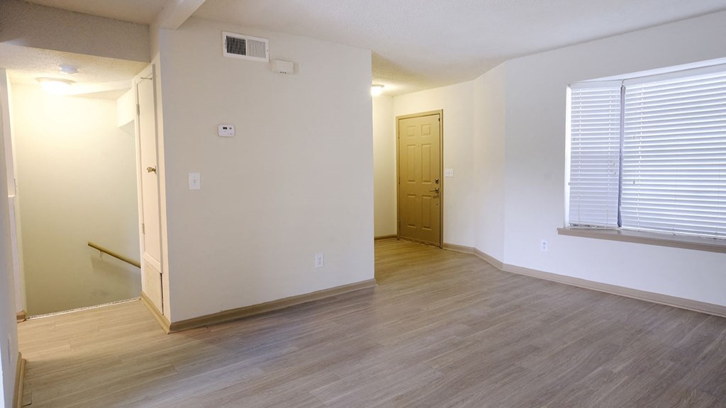 a bedroom with hardwood flooring and a large window