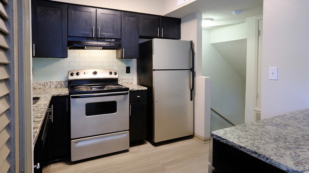 a kitchen with stainless steel appliances and black cabinets
