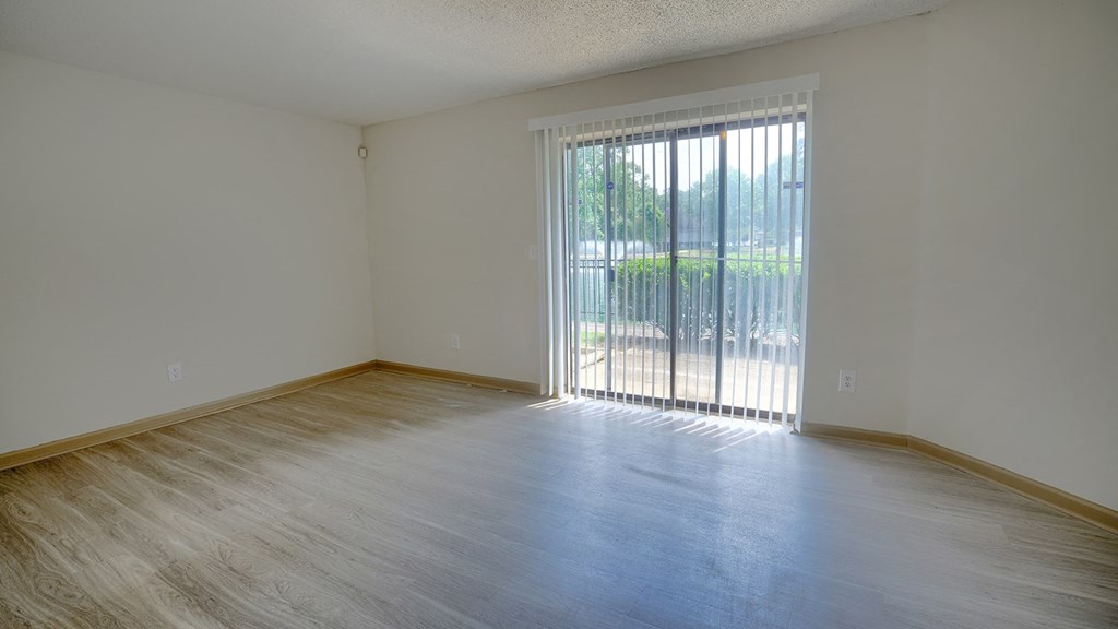 a bedroom with a sliding glass door and hardwood floors