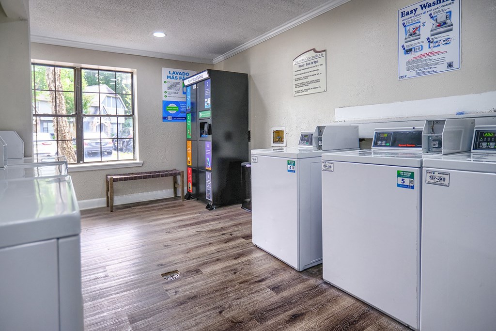 a laundry room with four washes and dryers in it and a window