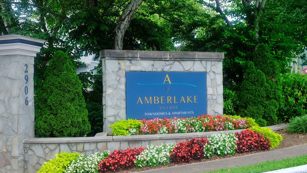 Front entrance of Amberlake Village with landscaped grounds and monument sign