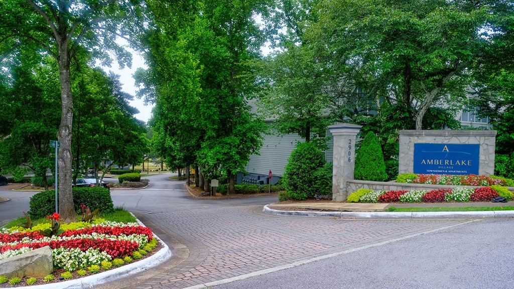 Driveway of Amberlake Village with landscaped grounds and monument sign